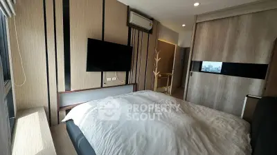 Modern bedroom with sleek design, featuring a wall-mounted TV and air conditioning, perfect for urban living.