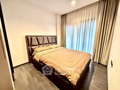 Modern bedroom with elegant design and large window draped with curtains