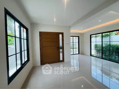 Spacious modern living room with large windows and garden view, perfect for natural light lovers.