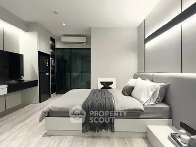 Modern bedroom with sleek design and neutral tones, featuring a cozy bed and stylish decor.