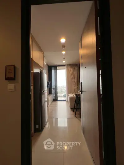 Modern apartment entrance leading to a cozy living room with a balcony view.