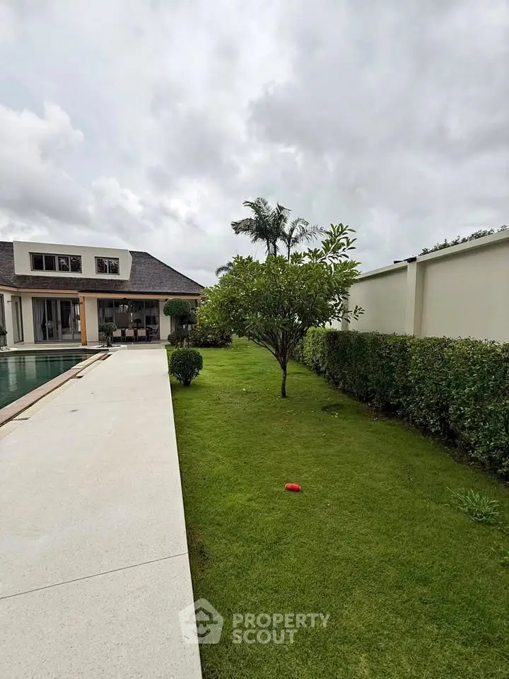 Luxurious modern home with pool and lush garden, perfect for relaxation and entertaining.