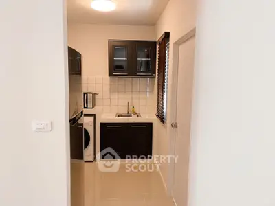 Modern compact kitchen with sleek cabinets and washing machine