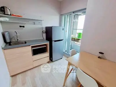 Compact kitchen with modern appliances and balcony view