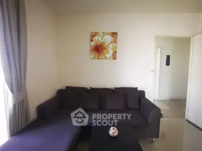 Cozy living room with dark sofa and floral wall art