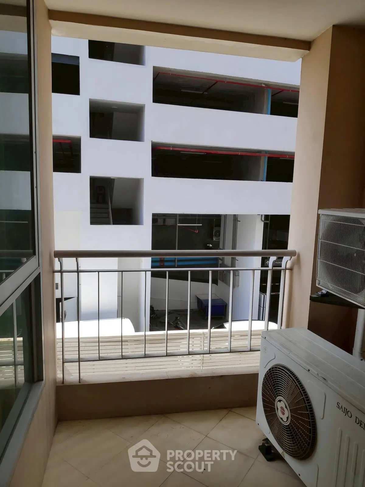 Modern balcony with air conditioning unit overlooking a contemporary building facade.