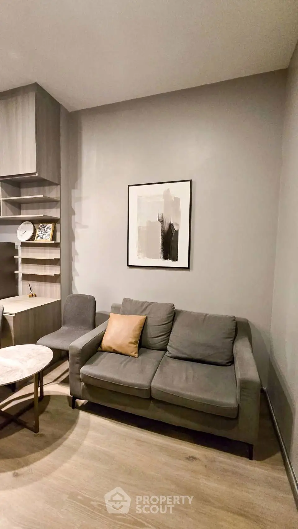 Modern living room with stylish gray sofa and abstract art on the wall.