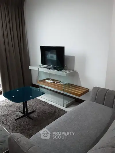 Modern living room with sleek TV stand and cozy gray sofa, perfect for relaxation.