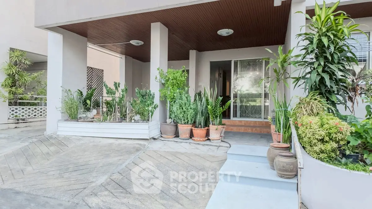 Charming entrance with lush potted plants and modern design