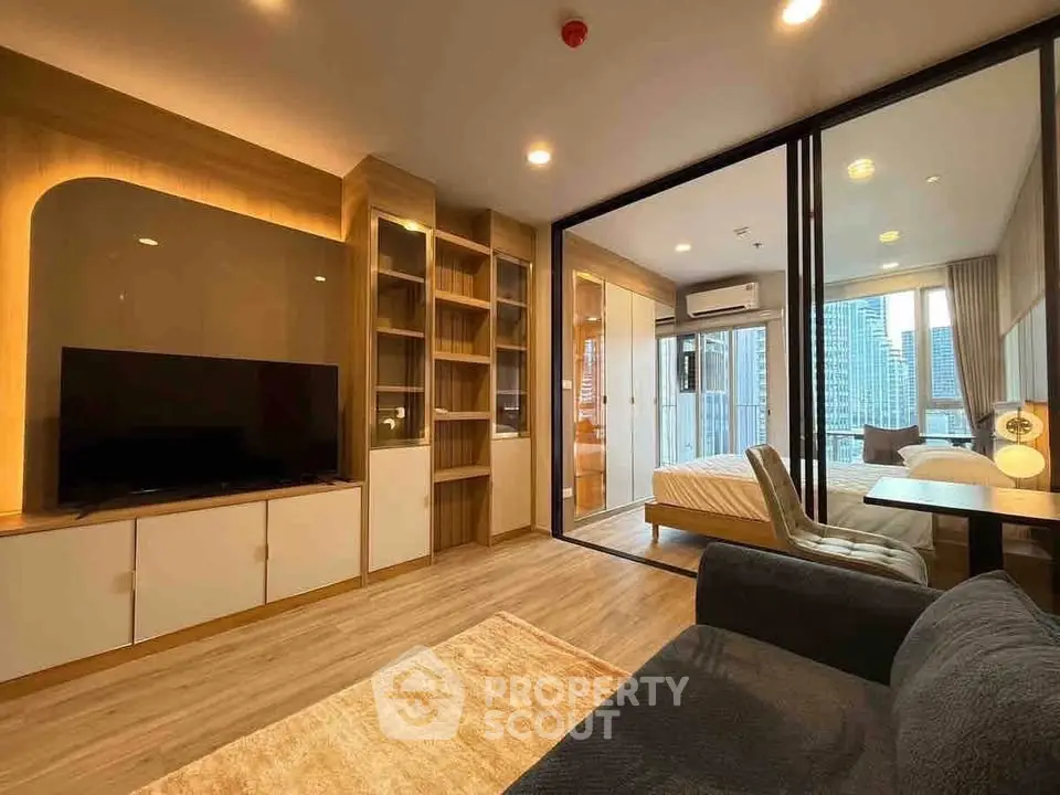 Modern living room with open layout and city view, featuring stylish furniture and natural lighting.