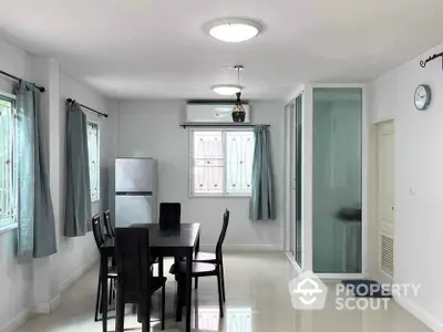 Spacious dining area with modern furniture and natural light in a contemporary home.