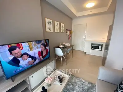 Modern living room with cozy decor and open kitchen layout, featuring a TV and dining area.