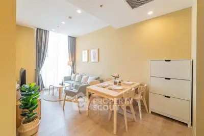 Modern living room with dining area, stylish decor, and natural light