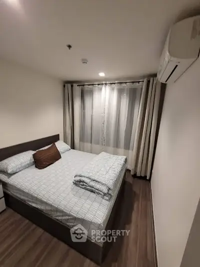 Cozy bedroom with modern decor and air conditioning, perfect for relaxation.