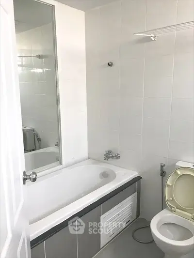 Modern bathroom with bathtub and white tile design, perfect for relaxation.