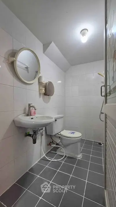 Compact bathroom with modern fixtures and tiled flooring