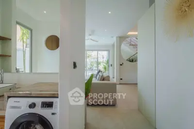 Modern open-plan living room with washing machine and stylish decor