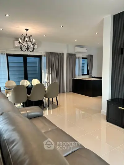 Elegant living room with chandelier and dining area, modern interior design