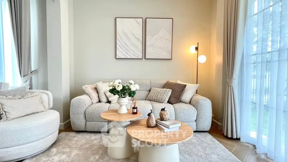 Elegant living room with cozy sofa, modern decor, and natural light