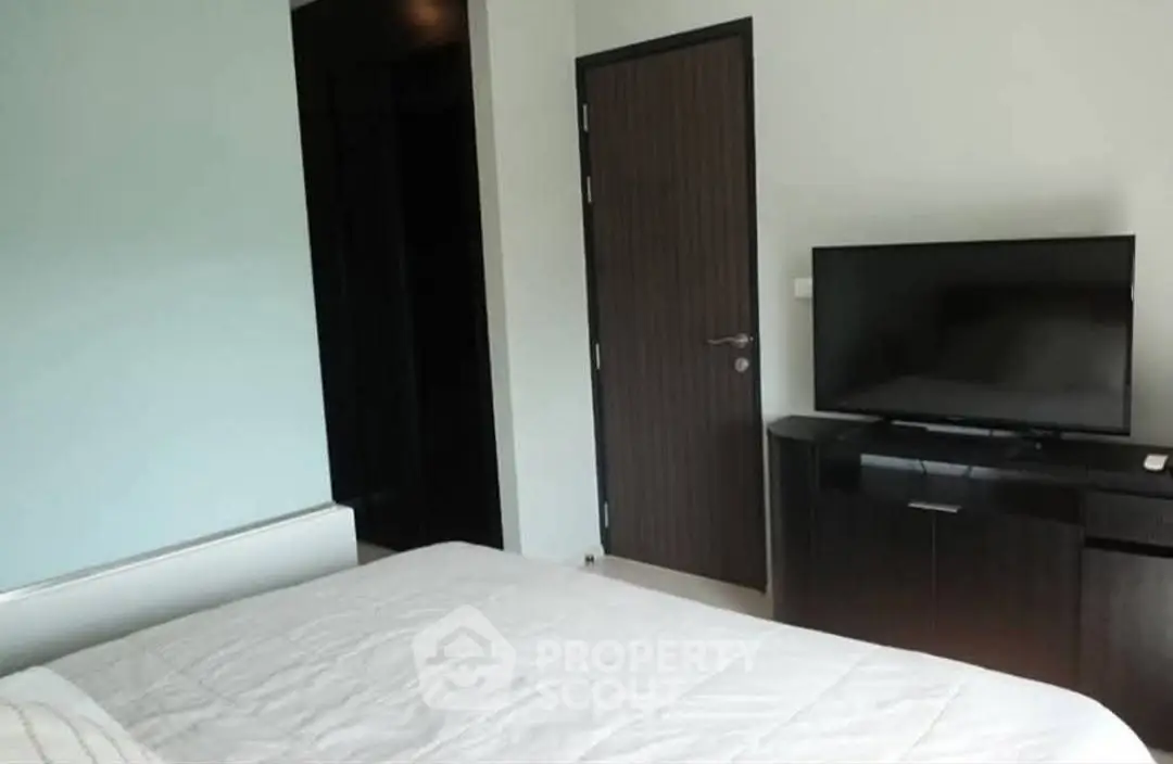 Modern bedroom with sleek TV stand and cozy bed, perfect for relaxation.