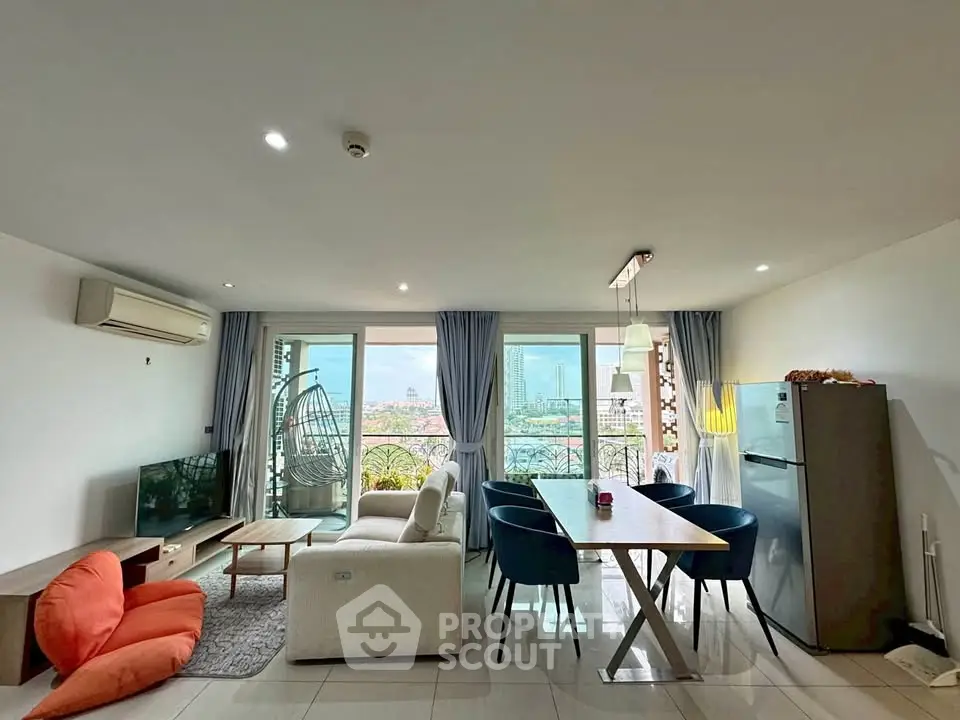 Spacious living room with modern furniture and balcony view in a high-rise apartment.