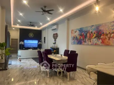 Elegant living room with modern decor, vibrant artwork, and stylish dining area, perfect for contemporary living.