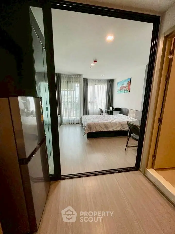 Modern bedroom with large windows and sleek design in a contemporary apartment.