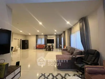 Spacious modern living room with elegant furniture and ample natural light, perfect for relaxation and entertainment.