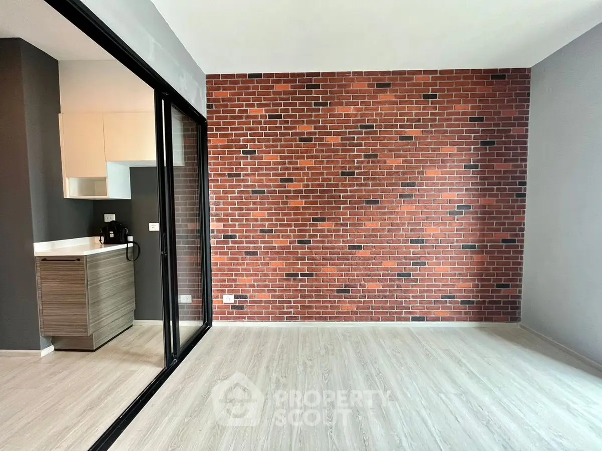Modern apartment with exposed brick wall and open kitchen layout, perfect for urban living.