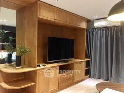 Modern living room with wooden built-in entertainment center and flat-screen TV, featuring stylish decor and ambient lighting.