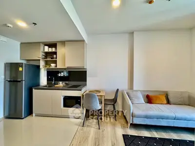 Modern open-layout kitchen and living room with sleek design and cozy seating area.