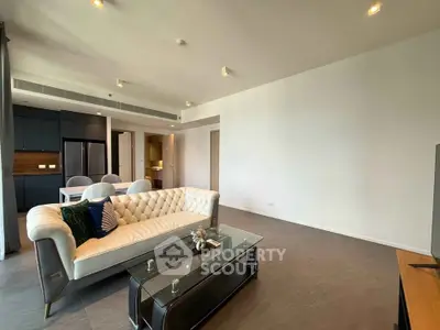 Spacious modern living room with elegant sofa and dining area in open layout apartment.