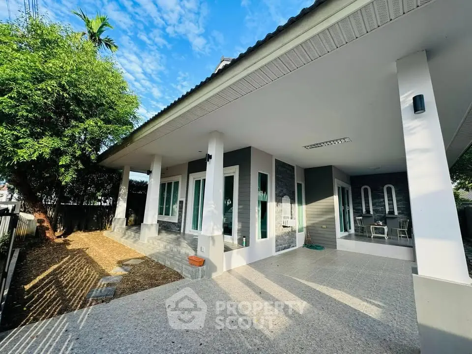 Charming modern home exterior with spacious covered patio and lush greenery.