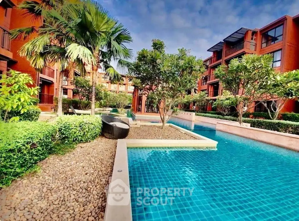 Luxurious residential complex with stunning pool and lush greenery, perfect for relaxation and leisure.