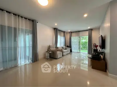 Spacious living room with modern decor and garden view, perfect for relaxation.