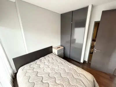 Modern bedroom with sleek wardrobe and cozy bed in stylish apartment.