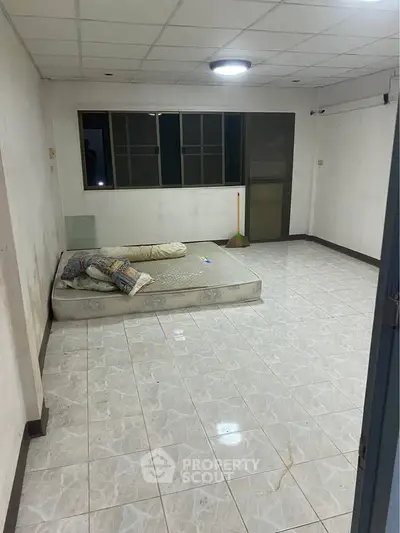 Spacious unfurnished room with tiled flooring and large windows, ideal for customization.