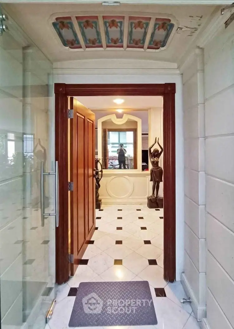 Elegant entrance with marble flooring and artistic ceiling design