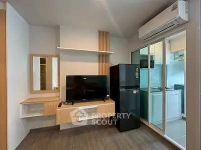 Modern living room with sleek TV setup and compact kitchen area