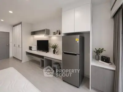 Modern studio apartment with sleek design, featuring a compact kitchen and stylish living area.