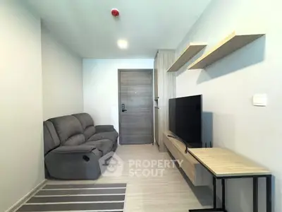 Modern living room with sleek furniture and wall-mounted TV in a cozy apartment.