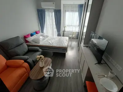 Modern studio apartment with cozy living area and bedroom, featuring stylish furniture and natural light.