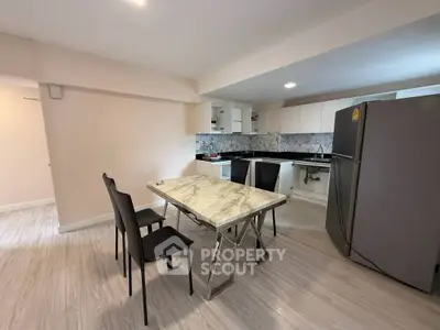 Modern kitchen with marble dining table and sleek appliances in open layout