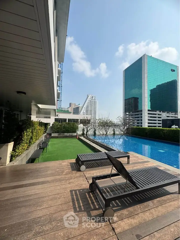 Luxurious rooftop pool with stunning city views and modern lounge chairs, perfect for relaxation and leisure.