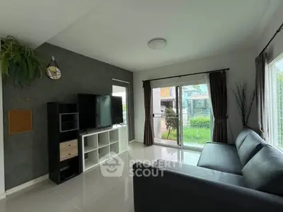 Modern living room with sleek furniture and large windows overlooking a lush garden, perfect for relaxation.