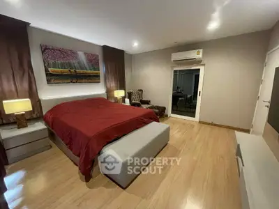 Spacious bedroom with modern decor and wooden flooring