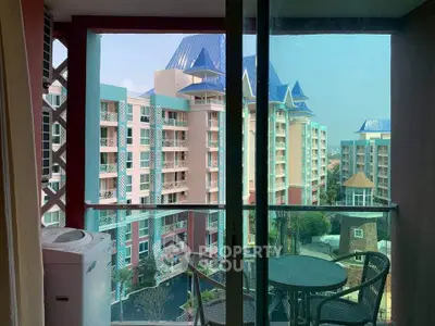 Charming balcony view of colorful residential buildings with outdoor seating and washing machine.