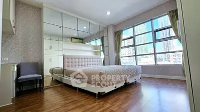 Spacious bedroom with large windows and city view in modern apartment