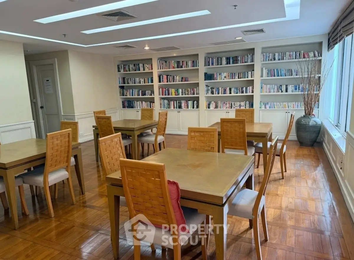 Elegant library with wooden tables and bookshelves in a modern real estate setting.