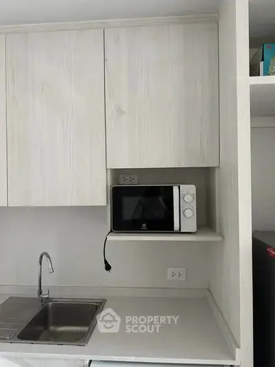 Modern kitchen with sleek cabinetry and built-in microwave